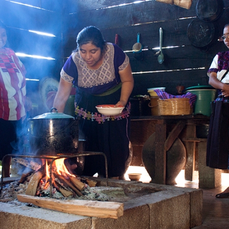 Esa fotografía muestra a Elvia, nuestra presidente actual, cocinando junto con su madre y su hermana en su casa, ubicada en el municipio de Oxchuc, Chiapas.